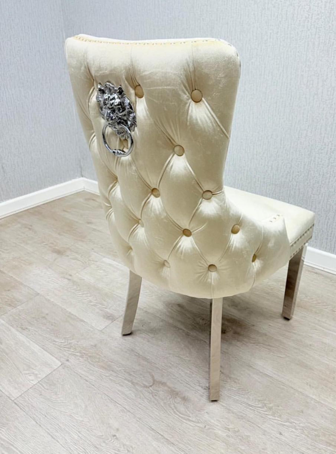 Beige tufted chair with decorative lion head on a light wooden floor and gray wall background