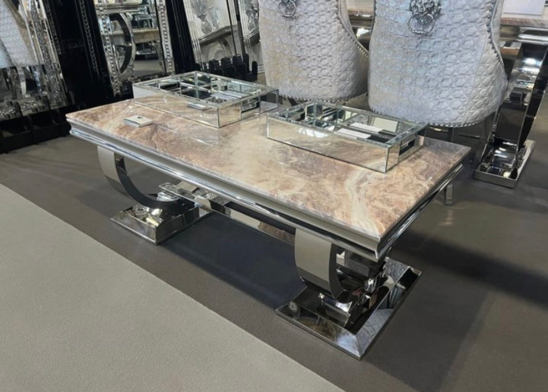 A beige marble coffee table with a chrome leg