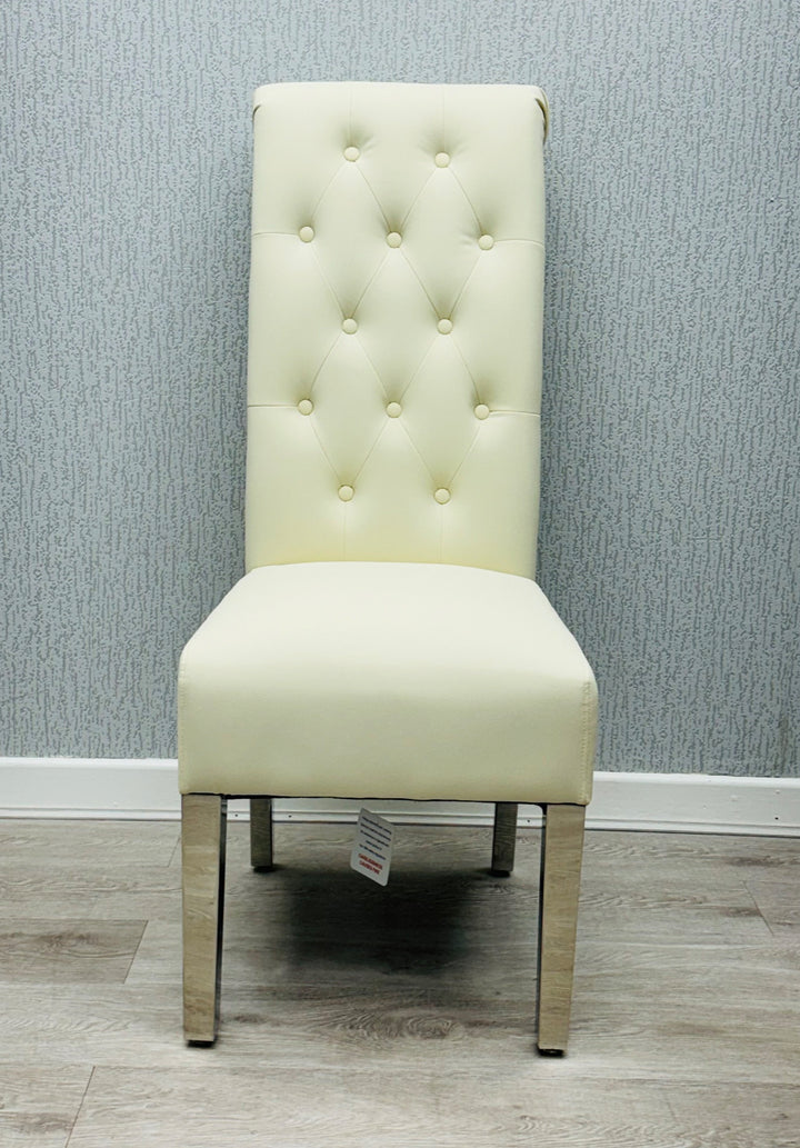 A single cream-colored dining chair with a high tufted backrest and upholstered back, seat, and legs made of wood.