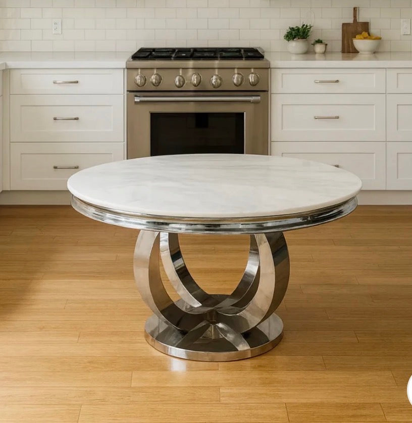 A round dining table with a white marble top and a polished chrome spiral base, set in a modern kitchen pedestal Table 