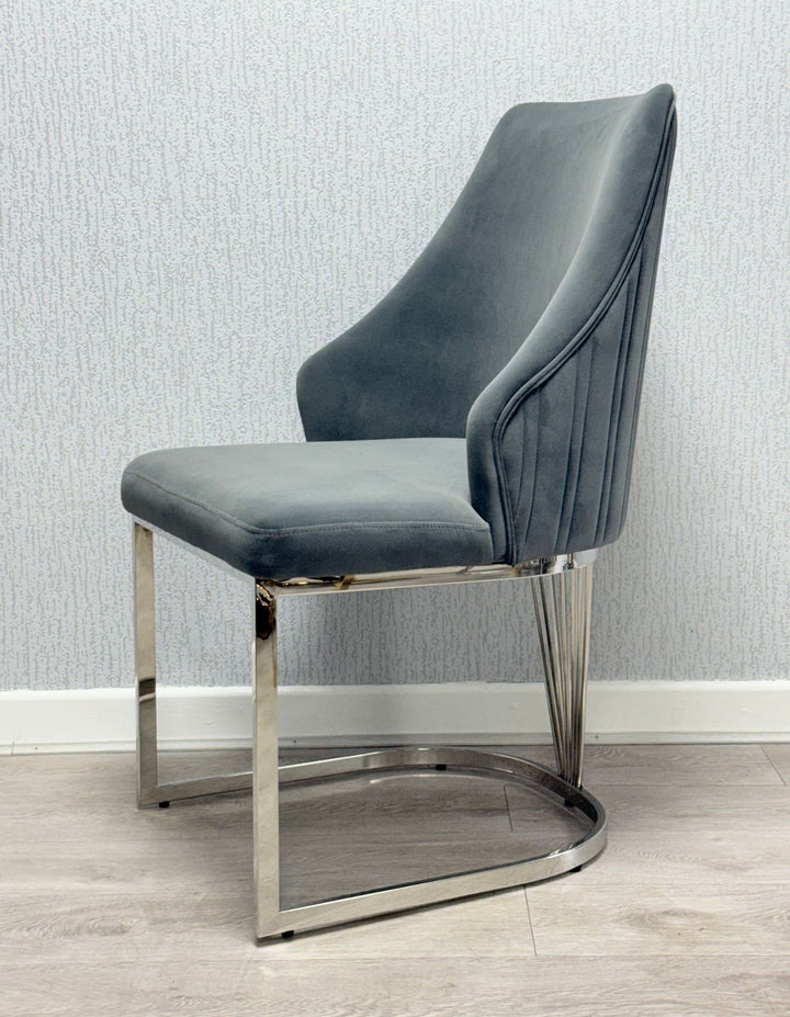 A grey upholstered dining chair with a chrome metal frame and a cushioned seat and backrest.