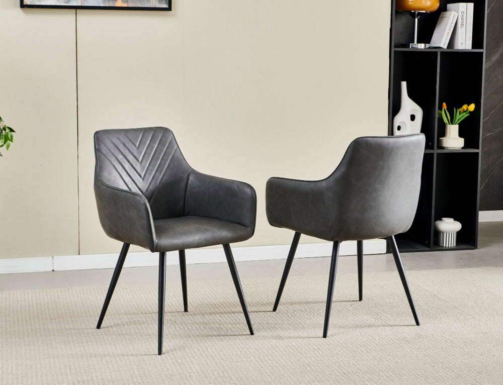Two gray armchairs in a room with a bookshelf and decor items.
