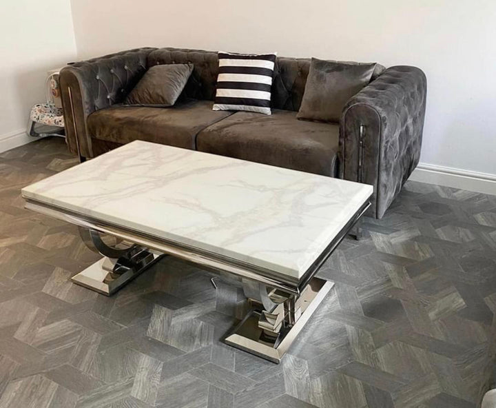 A white marble coffee table with a chrome leg